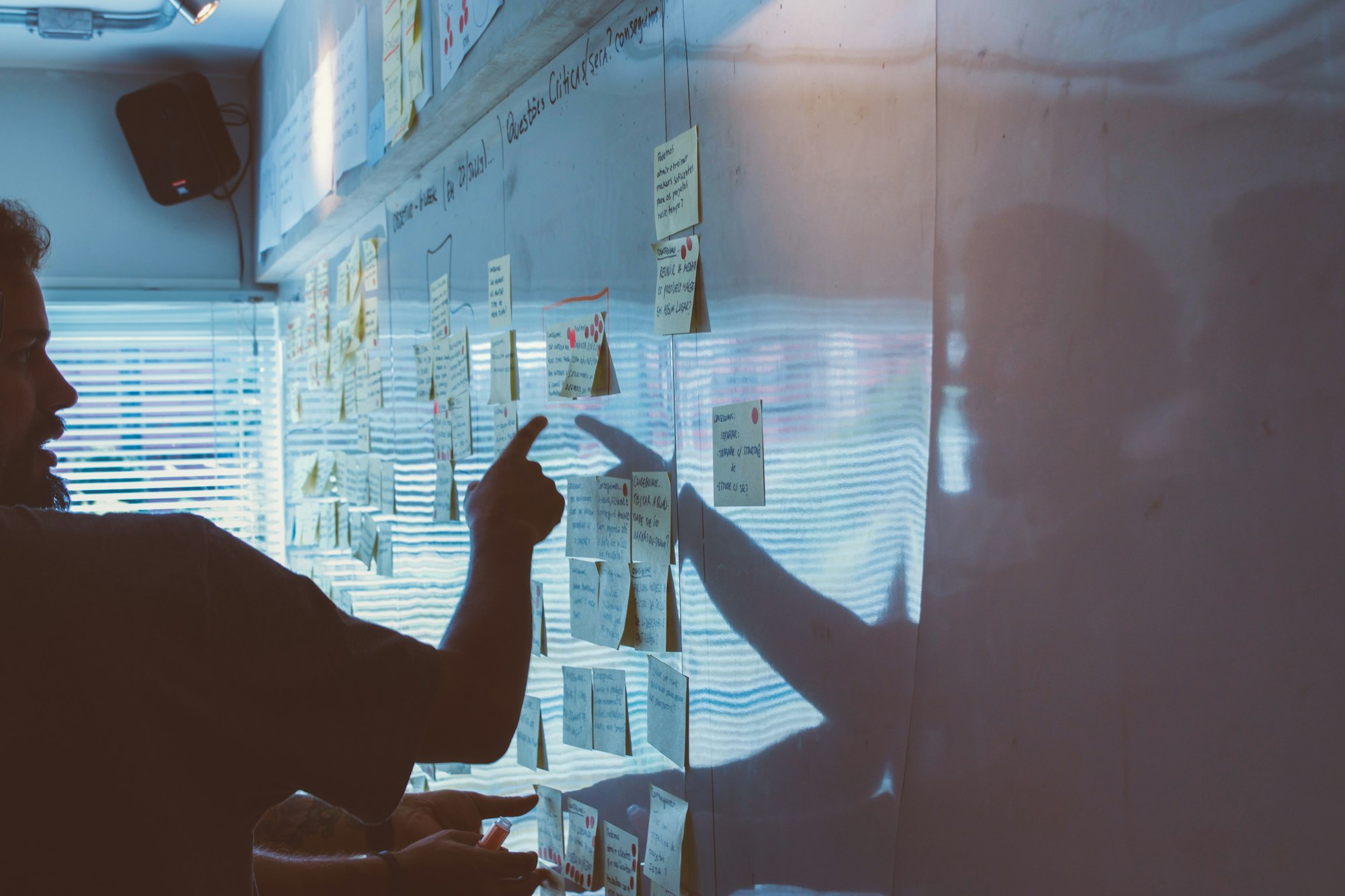 A person arranging sticky notes on a whiteboard.
